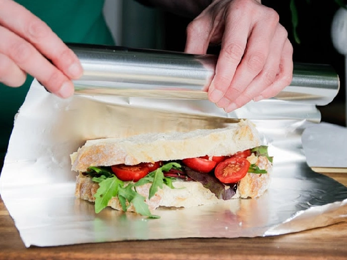 مردی در حال پیچاندن ساندویچ