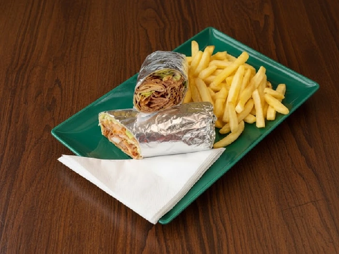 ساندویچ درون پاکت ساندویچ متلایز به دو تکه درون سینی سبز رنگ با کلی سیب زمینی