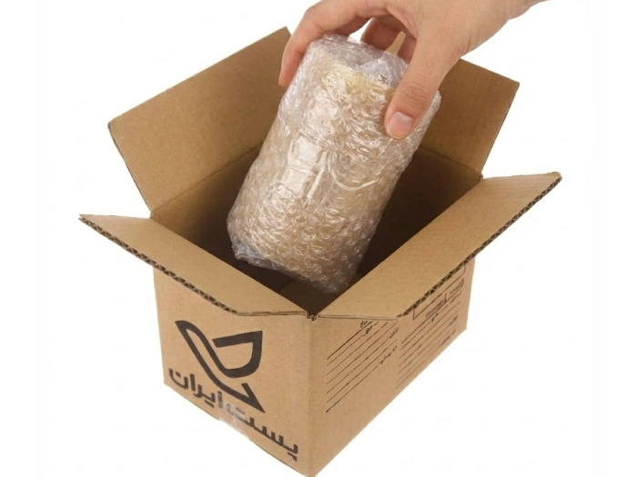 شمع بسته بندی شده در حال قرار گرفتن در کارتن پستی