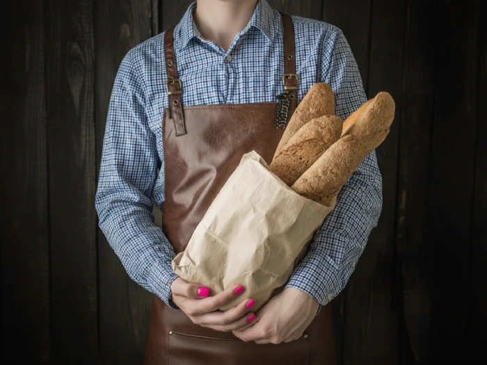 خانمی پاکت کرافت پر از نان را در بغل گرفته