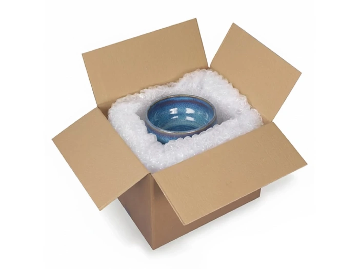 کارتن پستی و نایلون حباب دار و ظرف سرامیکی درون آن