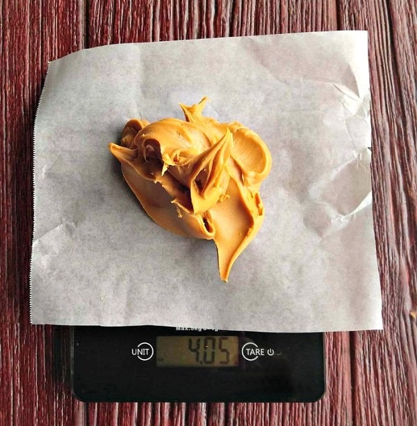 'وزن کردن غذا با ترازو خانگی پوشیده با کاغذ پوستی